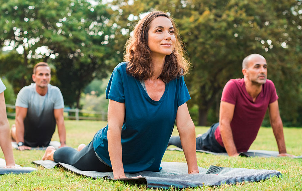 Gemischte Gruppe macht zufrieden Yoga im Park