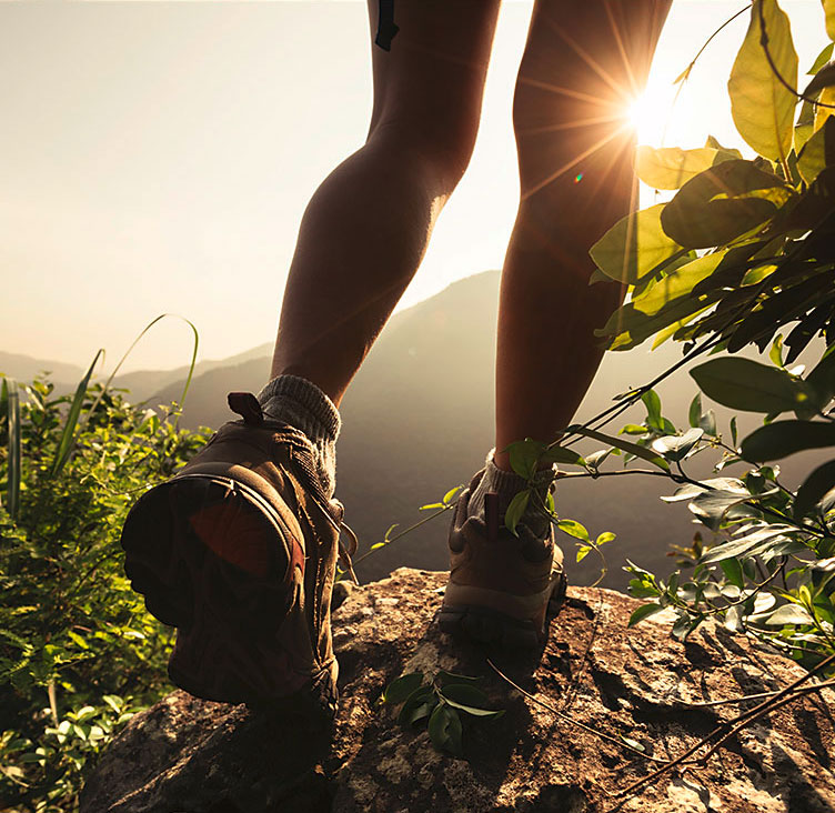 Beine einer Joggerin auf einem Berg beim Sonnenaufgang