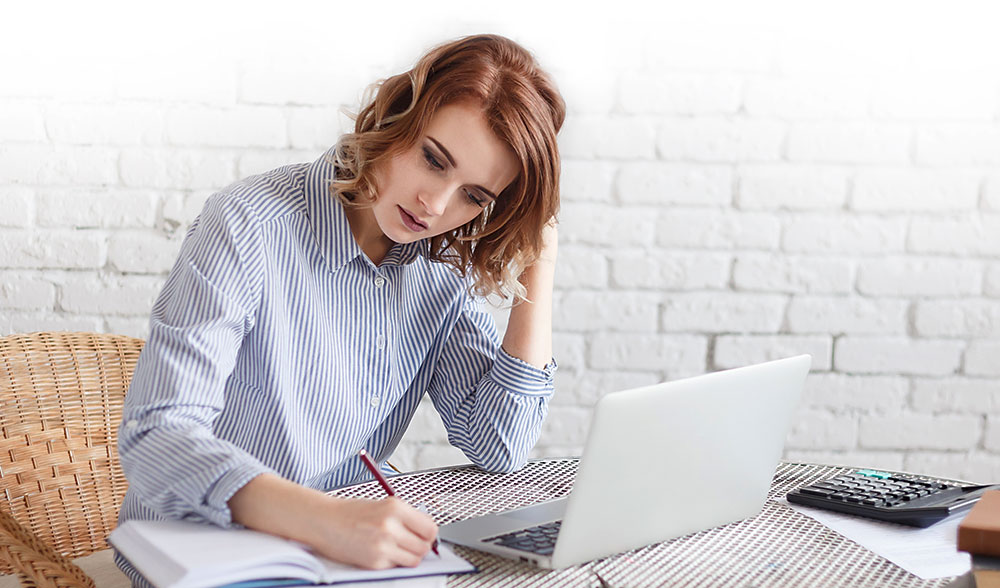 Junge Frau plant ihr Vorhaben am Laptop