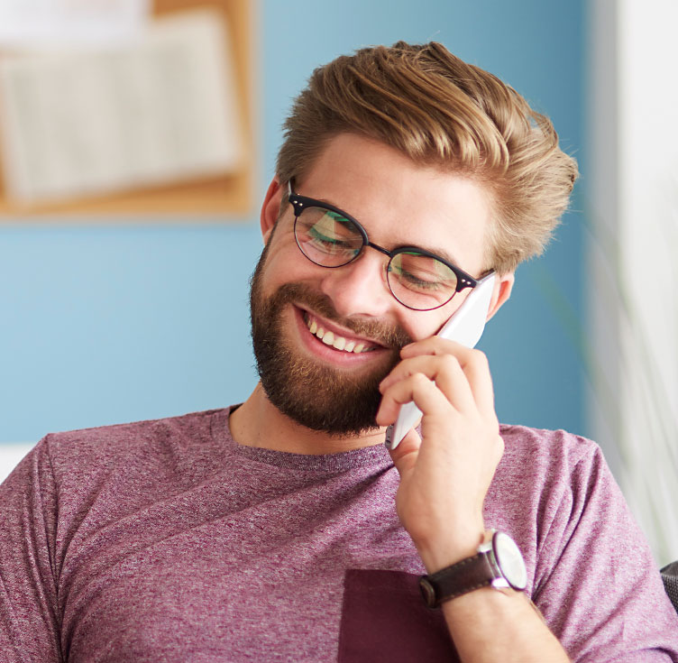 Junger Mann führt ein erfreuliches Telefonat