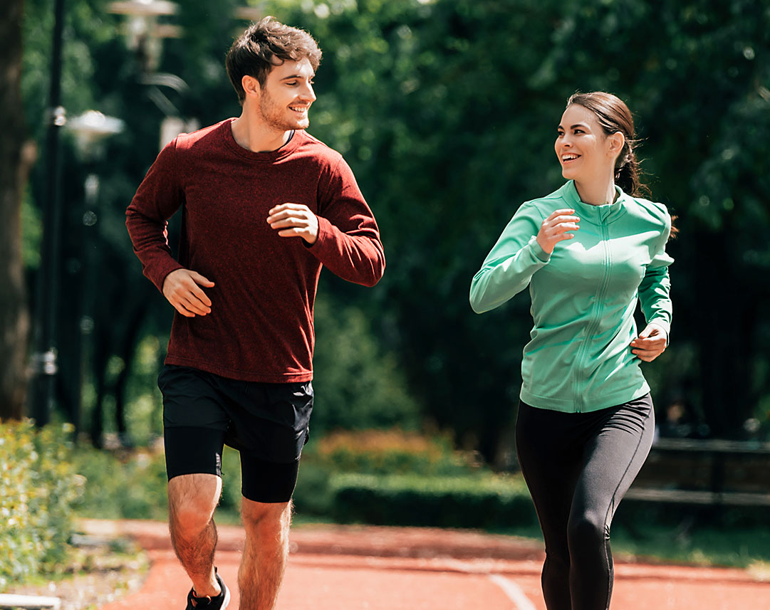 Junges Paar joggt auf dem Sportplatz