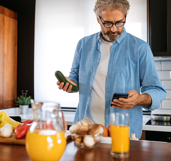 Mann kocht nach Rezept von Handy-App